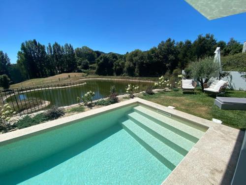 a swimming pool in a yard with a pond at Luxury Home - Vila Golfe Amarante in Amarante