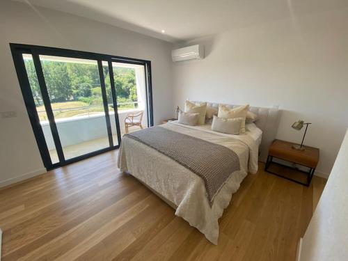 a bedroom with a bed and a large window at Luxury Home - Vila Golfe Amarante in Amarante