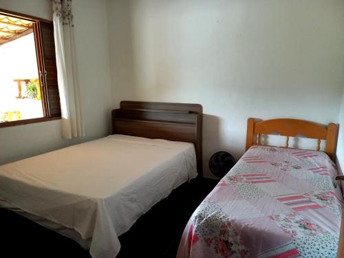 1 Schlafzimmer mit 2 Betten und einem Fenster in der Unterkunft RANCHO PÉ DA SERRA in Capitólio