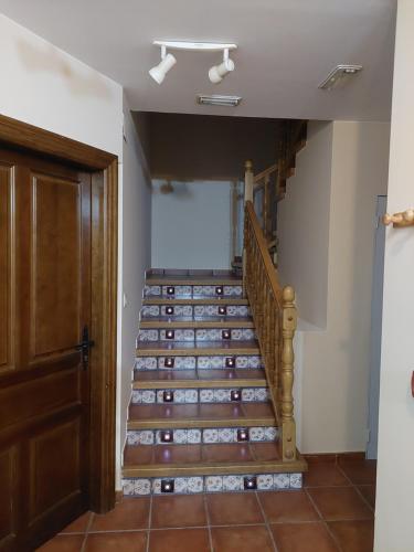 a staircase in a room with a door and a stair case at ALBERGUE CASA LAS ANGELITAS in Quel