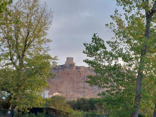 a castle on top of a mountain with trees at ALBERGUE CASA LAS ANGELITAS in Quel