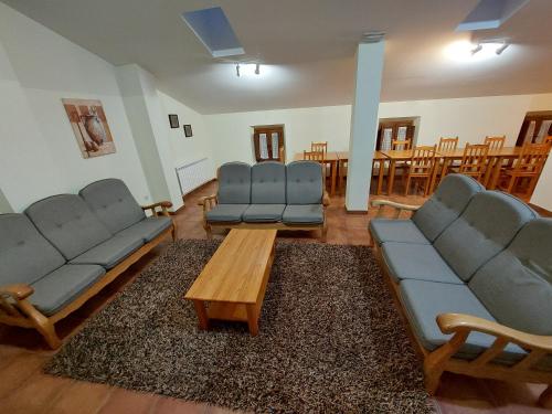 a living room with couches and a table and chairs at ALBERGUE CASA LAS ANGELITAS in Quel