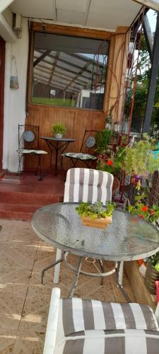 a patio with a table and chairs and plants at Hostal Destino Bellavista in Valparaíso