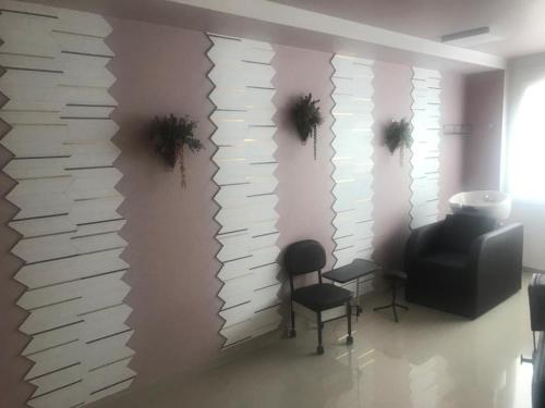 una habitación con sillas y una pared de papel en Amora Três, en São Paulo