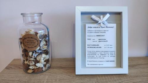 a glass bottle filled with shells and a card at Apart Harmony in Ruse