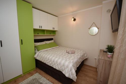 een slaapkamer met een bed met groen en wit bij Memento in Kragujevac