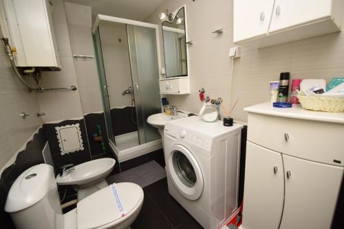 een badkamer met een toilet en een wasmachine bij Memento in Kragujevac