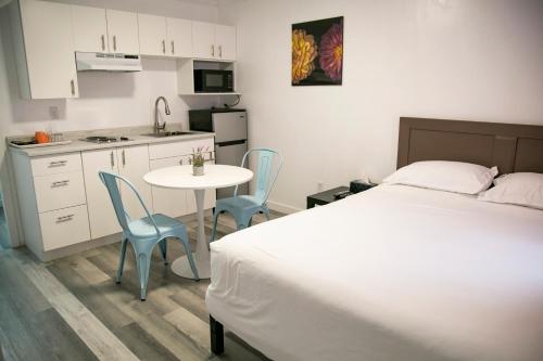 Schlafzimmer mit einem Bett, einem Tisch und Stühlen in der Unterkunft Westview Centre Motel in Powell River