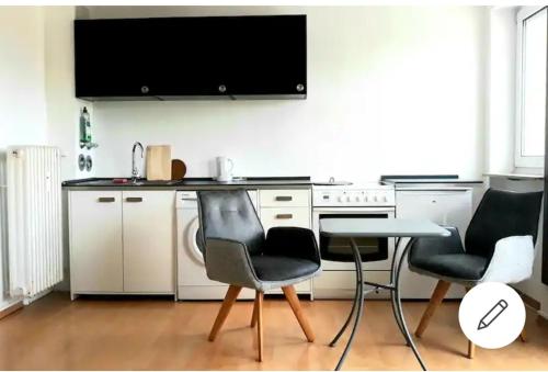 Il comprend une cuisine avec une table et deux chaises ainsi qu'une télévision. dans l'établissement Apartment Weitblick, à Schweinfurt