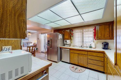 a kitchen with wooden cabinets and a stainless steel refrigerator at Sun in the City in Sun City