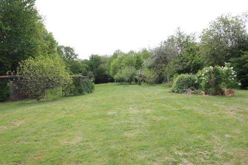 a large grass field with trees and bushes at Another Day in Paradise in Lizant
