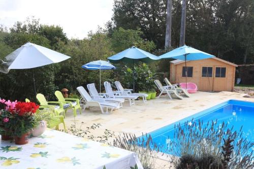 a patio with chairs and umbrellas and a pool at Another Day in Paradise in Lizant