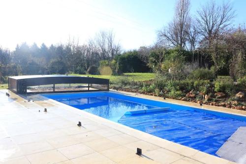 a swimming pool in a garden with a bridge at Another Day in Paradise in Lizant