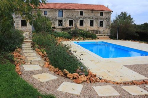 a backyard with a swimming pool and a house at Another Day in Paradise in Lizant