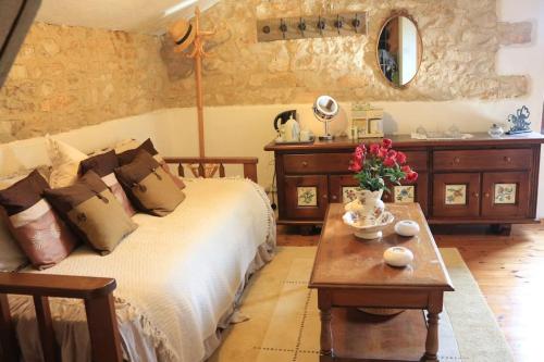 a bedroom with a bed and a table with flowers on it at Another Day in Paradise in Lizant