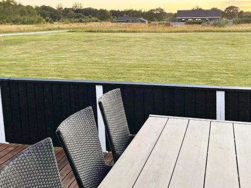 een tafel en stoelen op een terras met een veld bij 8 person holiday home in Storvorde in Egense