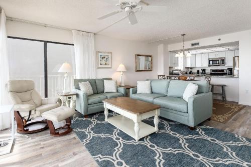 una sala de estar con 2 sofás azules y una mesa. en Gulfside 503 by Brooks and Shorey Resorts condo, en Fort Walton Beach