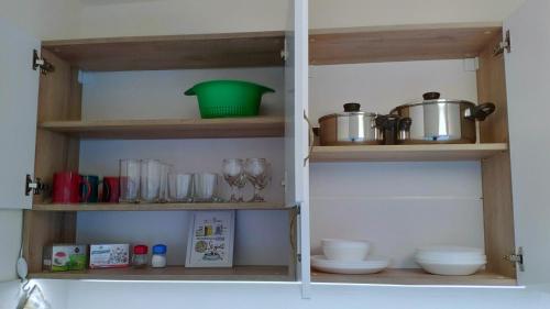 a pantry with wooden shelves with pots and pans at Apart Harmony in Ruse