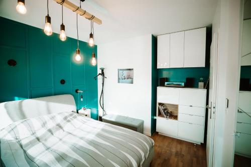 Un dormitorio con una cama y una pared verde. en L'Échappée Parisienne - Canal St-Denis, en Aubervilliers