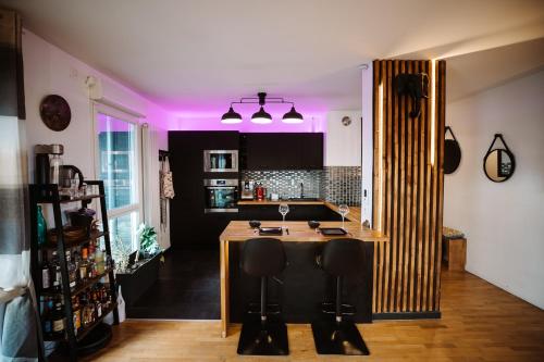 una cocina con una isla de madera en el centro en L'Échappée Parisienne - Canal St-Denis, en Aubervilliers