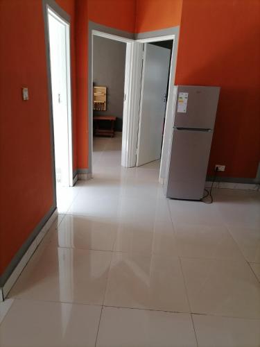 an empty room with orange walls and a white tile floor at Dream villa in Otse
