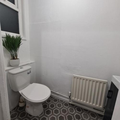 a white bathroom with a toilet and a radiator at Freshen-Up Stays in Oakengates