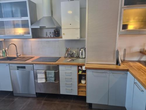 une cuisine avec des armoires blanches et un comptoir en bois dans l'établissement Le Loft 1936 : centre-ville + parking privé, au Havre