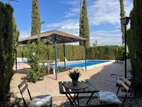 un patio con una mesa y una piscina en Granada Sights en Las Gabias