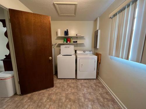 Il comprend une petite cuisine équipée d'une cuisinière et d'un lave-linge. dans l'établissement Verndale Apartment, à Salt Lake City