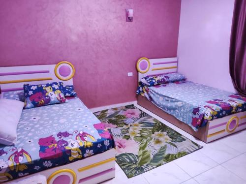 two beds in a room with pink walls at شاليه بالريف الاوربي للاجازات in Giza