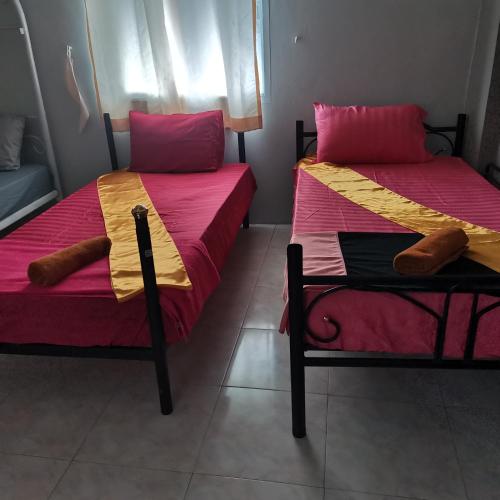 two beds sitting next to each other in a room at Haadrin Village near the pier in Haad Rin