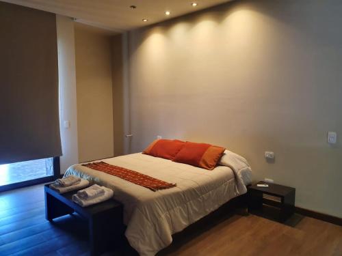 Dormitorio con cama con almohada naranja en Casa Atamisque en San Rafael
