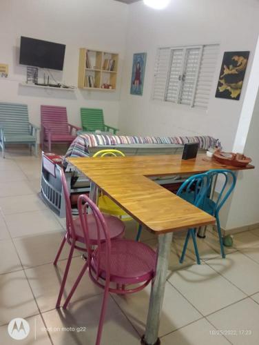 a table with colorful chairs in a room at Singela Casa em Chapada dos Guimarães in Chapada dos Guimarães