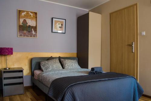 a bedroom with a bed with a blue comforter at Mungo Jerry Studio Apartment in the Old Town in Poznań