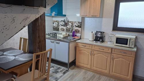 a small kitchen with a table and a microwave at Casa Luna in Gura Humorului