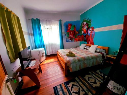 a bedroom with a bed in a room with blue walls at Hostal Destino Bellavista in Valparaíso