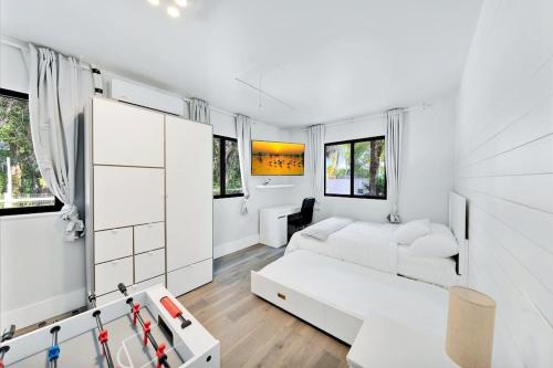 uma sala de estar com mobiliário branco e janelas em Farmhouse Miami em Miami