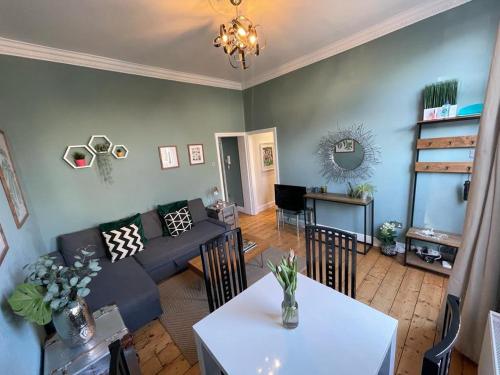 a living room with a couch and a table at By the Pagoda- cozy garden flat by Richmond & Kew Gardens in Kew Gardens