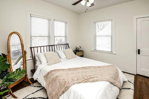 a bedroom with a bed and a fan and windows at Bungalow Adventures in Omaha