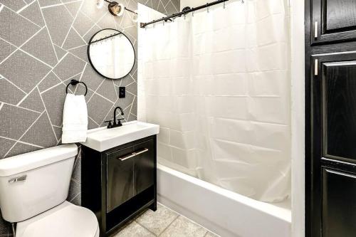 a bathroom with a toilet and a sink and a tub at Bungalow Adventures in Omaha