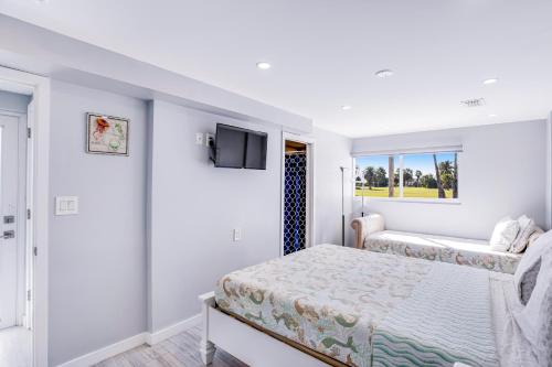 a bedroom with a bed and a tv on the wall at Vitamin Sea in Key Colony Beach