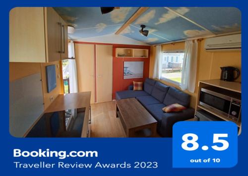 a living room with a couch and a table in a caravan at Cloud Nine in Pataias