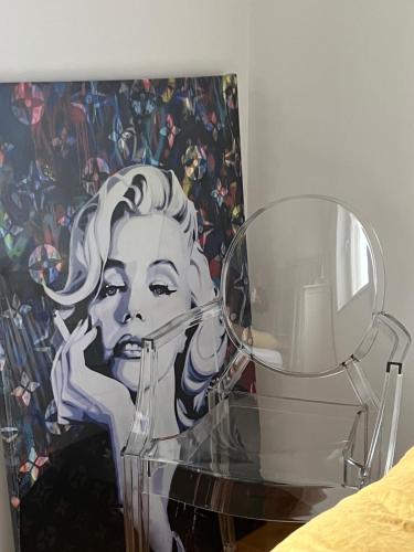 a glass table next to a painting of a woman at Sea View Apartment in Matulji