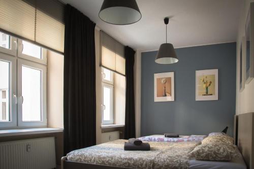 um quarto com uma cama e duas janelas em Milo Mi - 2 Bedroom Apartment in the Old Town em Poznań