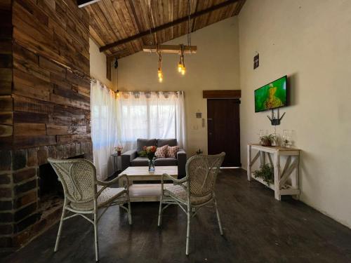 uma sala de estar com uma mesa e cadeiras e um sofá em La Casita de Charo 2 em Constanza