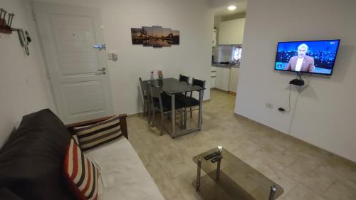 a living room with a couch and a table and a television at SOL Y RÍO in Colón