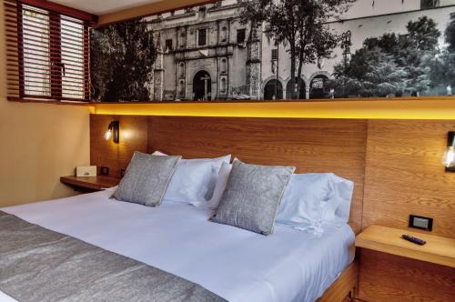 Schlafzimmer mit einem weißen Bett mit einem Kopfteil aus Holz in der Unterkunft Mi Zona Lodging Coyoacán in Mexiko-Stadt