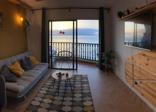 a living room with a couch and a view of the ocean at The view will convince you! in Puerto de Santiago