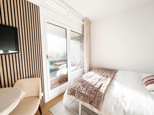 a white bedroom with a bed and a window at Bright Tiny Studio - Shared Pool & Sauna - Free Parking - Air condition in Muralto