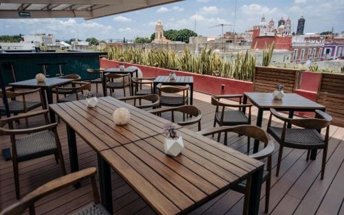 a patio with tables and chairs and a view of the city at Casa Azulai Puebla Hotel Boutique in Puebla